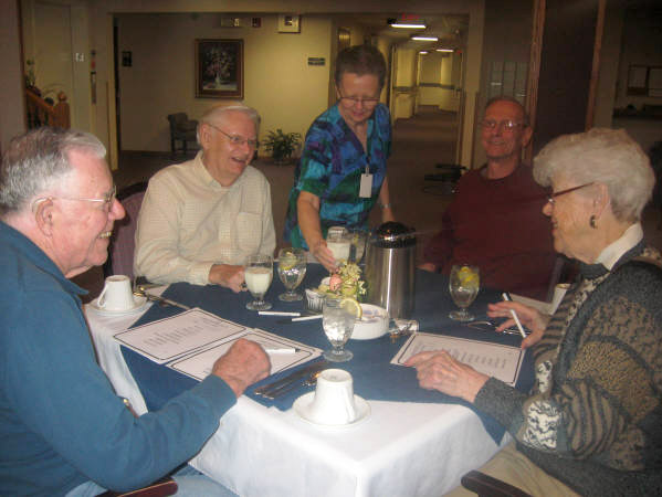 Group of residents sitting at a table, smiling and laughing