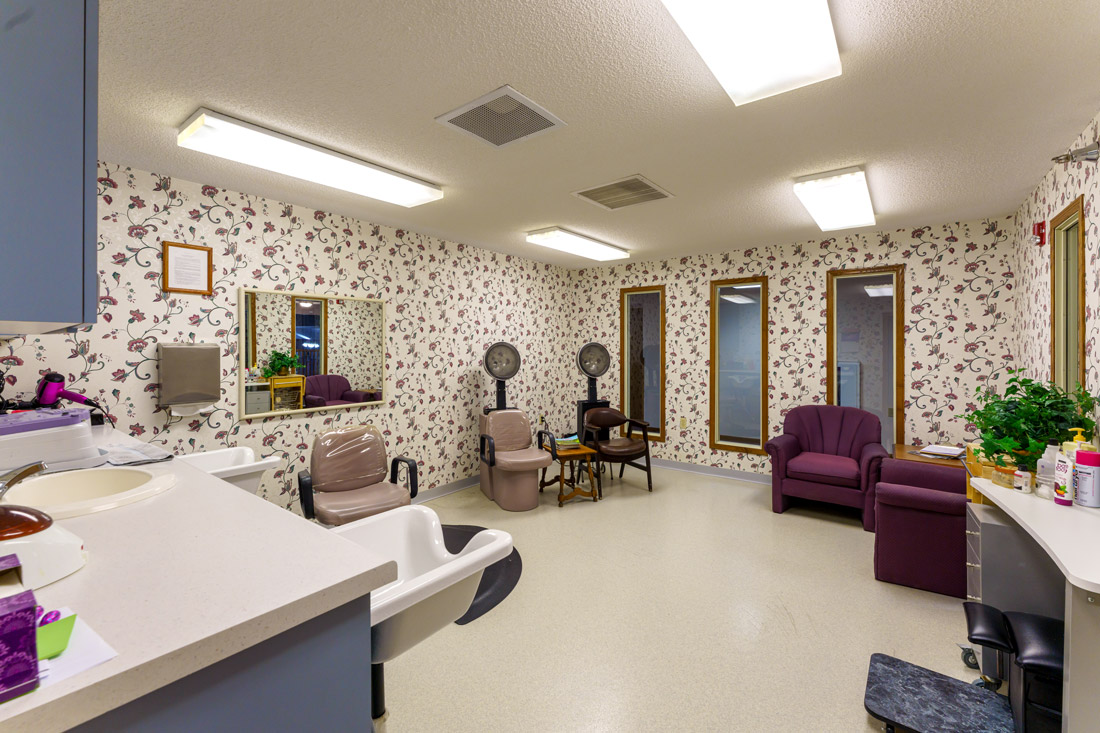 Lake Pointe Villa beauty salon with floral wallpaper and comfortable seats.