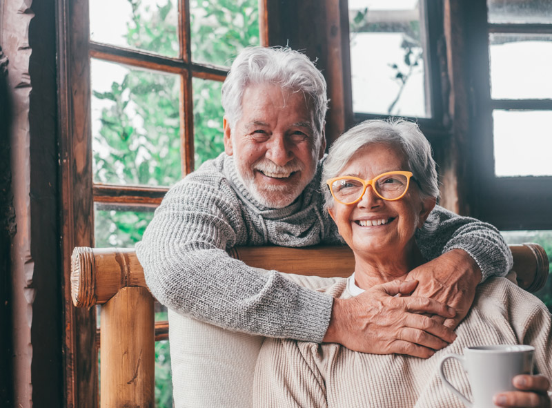 An older couple, relaxing and smiling.